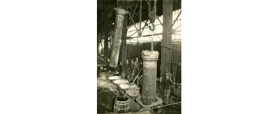 Démoulage de tuyaux de fonte coulés verticalement à l'usine de Pont-à-Mousson entre 1900 et 1932
