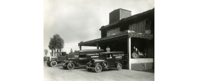 Usine Norton à La Courneuve en 1941 : devant le quai de chargement des produits, le service de livraison charge des meules abrasives dans les véhicules de la Compagnie des Meules Norton