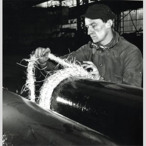 Pose d'une corde de protection autour du tuyau en vue du stockage à l'usine de Pont-à-Mousson dans les années 1950