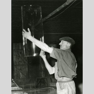 Verrier contrôlant un manchon à la verrerie de Saint-Just dans les années 1960