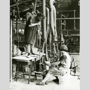 Un "gamin" tient le moule pendant le soufflage à la bouche d'une bouteille à la Verrerie d'Arleux, 1929